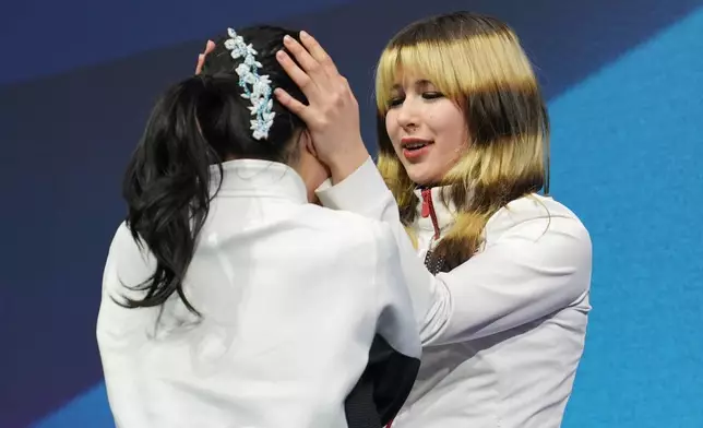 Gold medalist Alysa Liu of the United States hugs bronze medalist Ami Nakai of Japan after the women's figure skating free program at the 2026 Winter Olympics, in Milan, Italy, Thursday, Feb. 19, 2026. (AP Photo/Stephanie Scarbrough)
