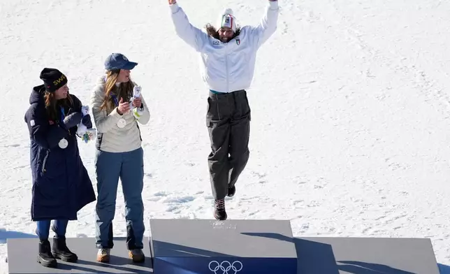 Italy's Federica Brignone, right, celebrates winning the gold medal in an alpine ski, women's giant slalom race, next to joint silver medalists Sweden's Sara Hector, left, and Norway's Thea Louise Stjernesund, at the 2026 Winter Olympics, in Cortina d'Ampezzo, Italy, Sunday, Feb. 15, 2026. (AP Photo/Andy Wong)