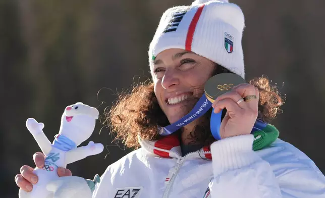 Italy's Federica Brignone shows her gold medal in an alpine ski, women's giant slalom race, at the 2026 Winter Olympics, in Cortina d'Ampezzo, Italy, Sunday, Feb. 15, 2026. (AP Photo/Jacquelyn Martin)
