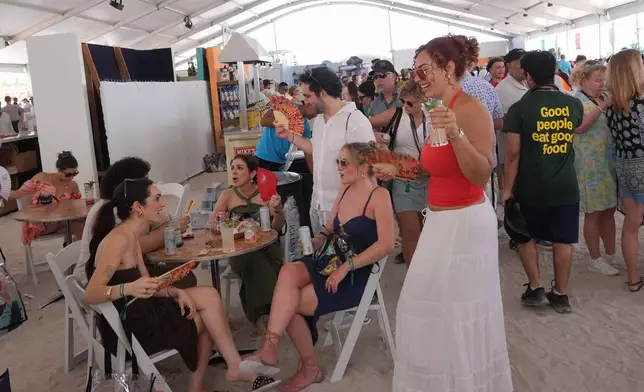 Friends take a break during the South Beach Wine and Food Festival Saturday, Feb. 21, 2026, in Miami Beach, Fla. (AP Photo/Marta Lavandier)