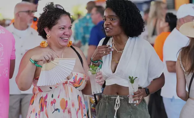 Friends walk the South Beach Wine and Food Festival Saturday, Feb. 21, 2026, in Miami Beach, Fla. (AP Photo/Marta Lavandier)