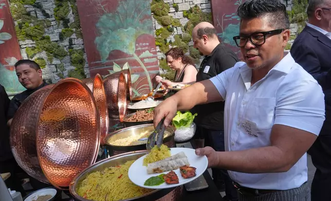 Patrick Garcia samples an array of Asian dishes during the South Beach Wine and Food Festival Friday, Feb. 20, 2026, in Miami Beach, Fla. (AP Photo/Marta Lavandier)