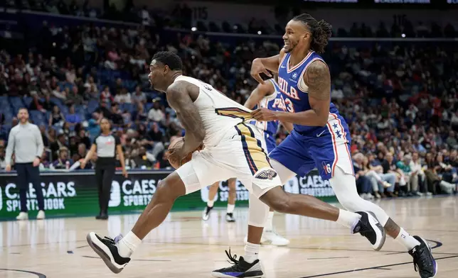New Orleans Pelicans forward Zion Williamson, left, is grabbed by Philadelphia 76ers forward Jabari Walker, right, during the first half of an NBA basketball game in New Orleans, Saturday, Feb. 21, 2026. (AP Photo/Matthew Hinton)