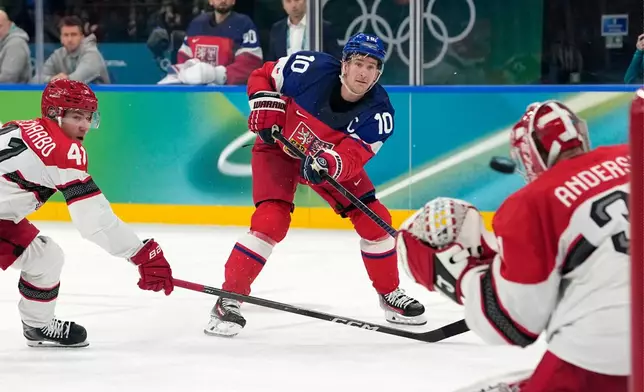 Czechia's Roman Cervenka (10) scores a goal against Denmark goalkeeper Frederik Andersen (31) during the second period of a men's ice hockey qualification playoff game at the 2026 Winter Olympics, in Milan, Italy, Tuesday, Feb. 17, 2026. (AP Photo/Hassan Ammar)