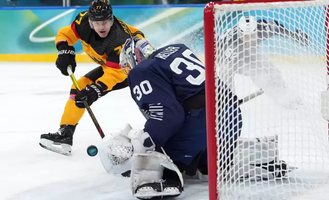 Germany's John Peterka (77) shoots against France goalkeeper Antoine Keller (30) during the second period of a men's ice hockey qualification playoff game at the 2026 Winter Olympics, in Milan, Italy, Tuesday, Feb. 17, 2026. (AP Photo/Carolyn Kaster)