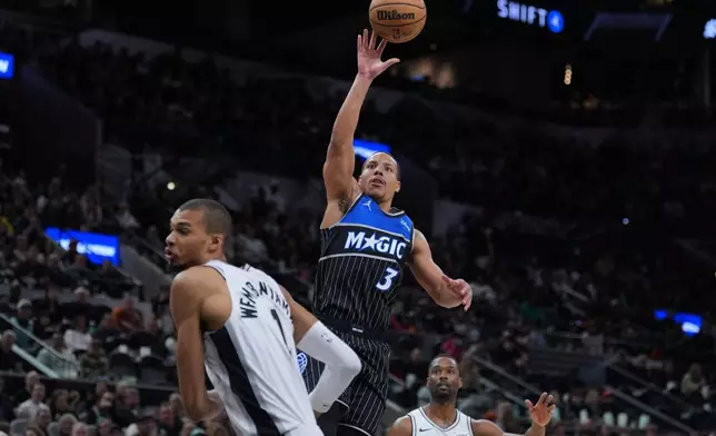 Orlando Magic guard Desmond Bane (3) shoots over San Antonio Spurs forward Victor Wembanyama (1) during the first half of an NBA basketball game in San Antonio, Sunday, Feb. 1, 2026. (AP Photo/Eric Gay)