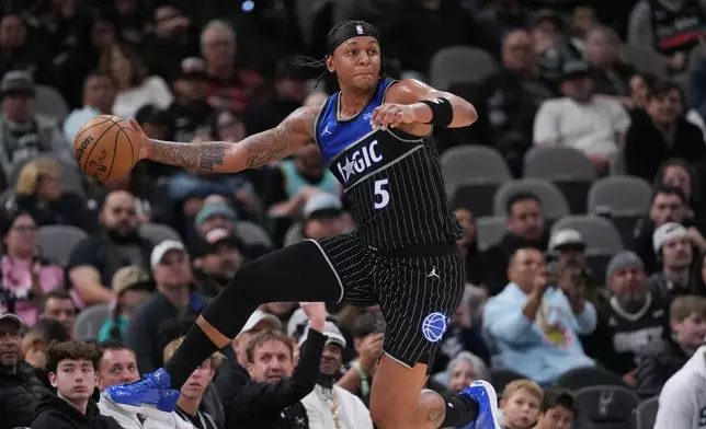 Orlando Magic forward Paolo Banchero (5) jumps to save a loose ball from going out of bounds during the first half of an NBA basketball game against the San Antonio Spurs in San Antonio, Sunday, Feb. 1, 2026. (AP Photo/Eric Gay)