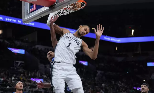 San Antonio Spurs forward Victor Wembanyama (1) scores against the Orlando Magic during the second half of an NBA basketball game in San Antonio, Sunday, Feb. 1, 2026. (AP Photo/Eric Gay)
