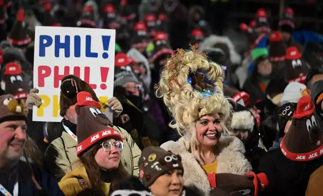 Toni Massey, of Bismack, N.D., right, celebrates while waiting for Punxsutawney Phil, the weather prognosticating groundhog, to come out and make his prediction during the 140th celebration of Groundhog Day on Gobbler's Knob in Punxsutawney, Pa., Monday, Feb. 2, 2026. (AP Photo/Barry Reeger)