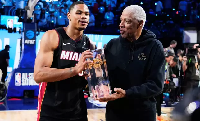 Miami Heat forward Keshad Johnson gets the winner's trophy from Julius Erving after winning the slam dunk contest at the NBA basketball All-Star weekend festivities Saturday, Feb. 14, 2026, in Inglewood, Calif. (AP Photo/Mark J. Terrill)