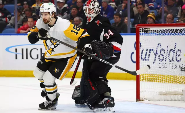 Pittsburgh Penguins center Tommy Novak (18) skates in the crease past Buffalo Sabres goaltender Alex Lyon (34) during the second period of an NHL hockey game, Thursday, Feb. 5, 2026, in Buffalo, N.Y. (AP Photo/Jeffrey T. Barnes)