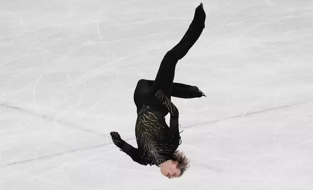 Ilia Malinin of the United States does a back flip while competing during the men's free skate program in figure skating at the 2026 Winter Olympics, in Milan, Italy, Friday, Feb. 13, 2026. (AP Photo/Stephanie Scarbrough)