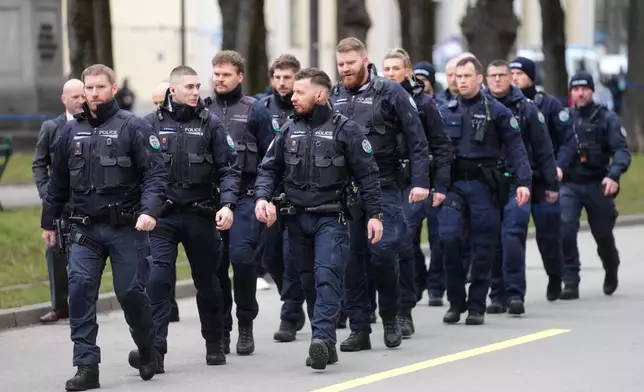 Police walk in formation to take their security positions around the Munich Security Conference in Munich, Germany, Friday, Feb. 13, 2026. (AP Photo/Michael Probst)