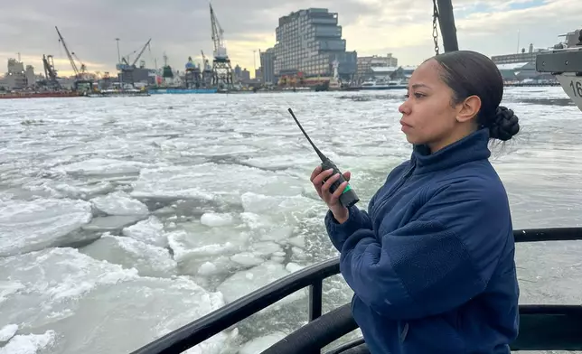 Coast Guard Seaman Leyla Siglam monitors ice breaking from the Coast Guard Cutter Hawser during an ice-clearing operation at Wallabout Bay in the East River in New York, Wednesday, Feb. 11, 2026. (AP Photo/Ted Shaffrey)