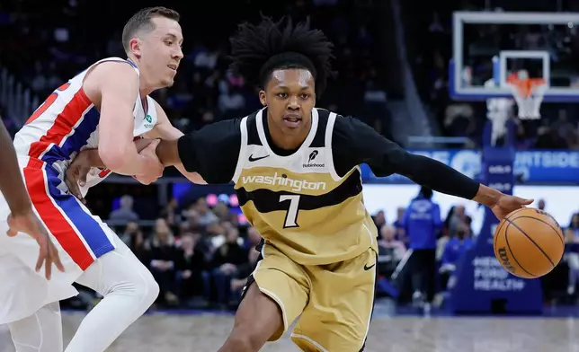Washington Wizards guard Bub Carrington (7) is held by Detroit Pistons forward Duncan Robinson, left, while trying to go to the basket during the first half of an NBA basketball game Thursday, Feb. 5, 2026, in Detroit. (AP Photo/Duane Burleson)