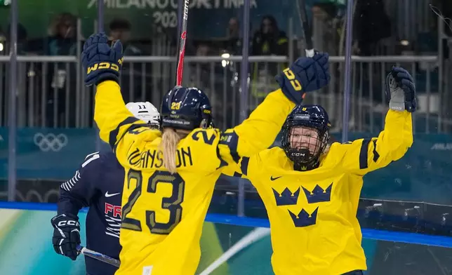 Sweden's Thea Johansson, left, celebrates after scoring her side's opening goal during a preliminary round match of women's ice hockey between the France and Sweden at the 2026 Winter Olympics, in Milan, Italy, Sunday, Feb. 8, 2026. (AP Photo/Petr David Josek)