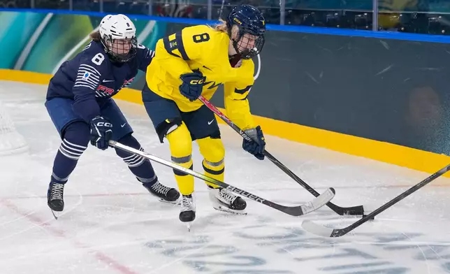 France's Jade Barbirati, left, challenges Sweden's Hilda Svensson during a preliminary round match of women's ice hockey between the France and Sweden at the 2026 Winter Olympics, in Milan, Italy, Sunday, Feb. 8, 2026. (AP Photo/Petr David Josek)