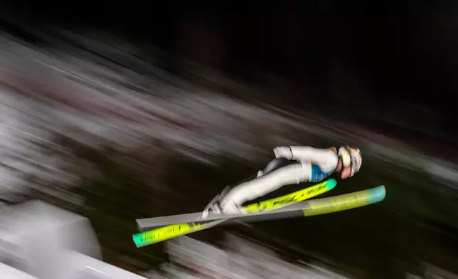 Meghann Wadsak, of Austria, soars through the air during her first round jump of the ski jumping women's normal hill individual, at the 2026 Winter Olympics, in Predazzo, Italy, Saturday, Feb. 7, 2026. (AP Photo/Evgeniy Maloletka)