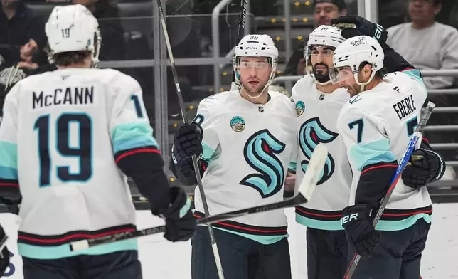 Seattle Kraken defenseman Vince Dunn (29) celebrates his goal with left wing Jared McCann (19), center Matty Beniers (10) and right wing Jordan Eberle (7) during the first period of an NHL hockey game Wednesday, Feb. 4, 2026, in Los Angeles. (AP Photo/Jae C. Hong)