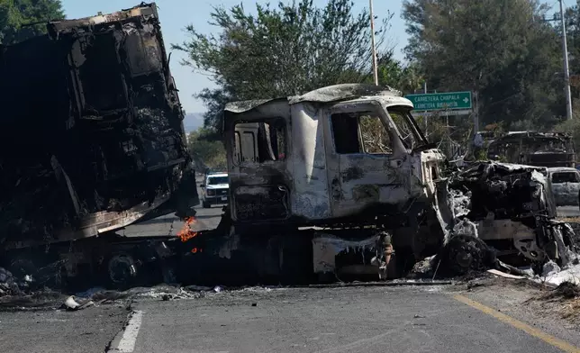 A charred truck blocks a road the day after the Mexican army killed Jalisco New Generation Cartel leader Nemesio Oseguera Cervantes, known as "El Mencho," in Guadalajara, Mexico, Monday, Feb. 23, 2026. (AP Photo/Marco Ugarte)
