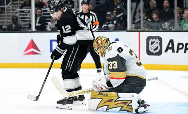 Los Angeles Kings left wing Trevor Moore (12) tries to deflect a pass into the goal against Vegas Golden Knights goaltender Adin Hill (33) in the second period of an NHL hockey game Wednesday, Feb. 25, 2026, in Los Angeles. (AP Photo/Wally Skalij)