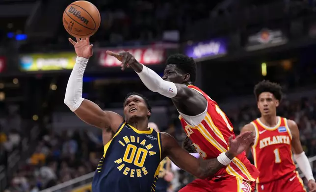 Indiana Pacers guard Bennedict Mathurin, left, looses the ball in front of Atlanta Hawks forward Mouhamed Gueye during the first half of an NBA basketball game in Indianapolis, Saturday, Jan. 31, 2026. (AP Photo/AJ Mast)
