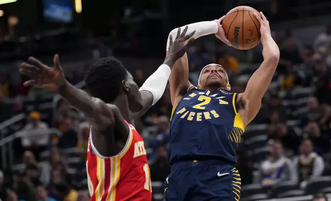 Indiana Pacers guard Andrew Nembhard, right, shoots over Atlanta Hawks forward Mouhamed Gueye during the first half of an NBA basketball game in Indianapolis, Saturday, Jan. 31, 2026. (AP Photo/AJ Mast)