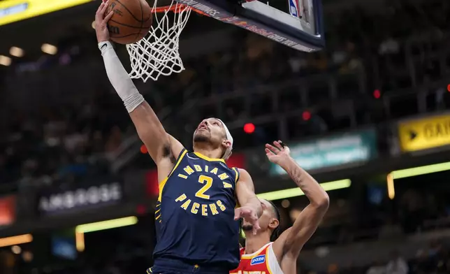 Indiana Pacers guard Andrew Nembhard, left, shoots in front of Atlanta Hawks forward Zaccharie Risacher during the first half of an NBA basketball game in Indianapolis, Saturday, Jan. 31, 2026. (AP Photo/AJ Mast)
