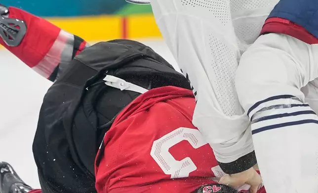 France's Pierre Crinon (7) fights with Canada's Tom Wilson (43) during a preliminary round game of men's ice hockey between Canada and France at the 2026 Winter Olympics, in Milan, Italy, Sunday, Feb. 15, 2026. (AP Photo/Hassan Ammar)