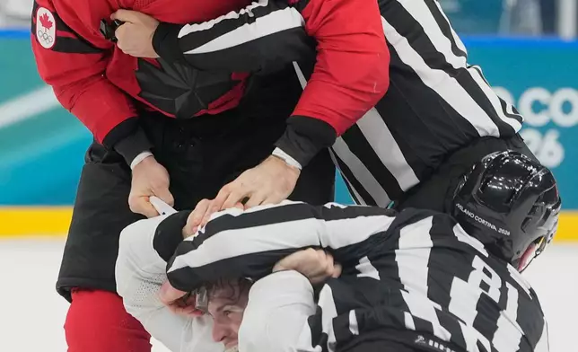 France's Pierre Crinon (7) and Canada's Tom Wilson (43) fight in the third period during a preliminary round game of men's ice hockey between Canada and France at the 2026 Winter Olympics, in Milan, Italy, Sunday, Feb. 15, 2026. (AP Photo/Hassan Ammar)