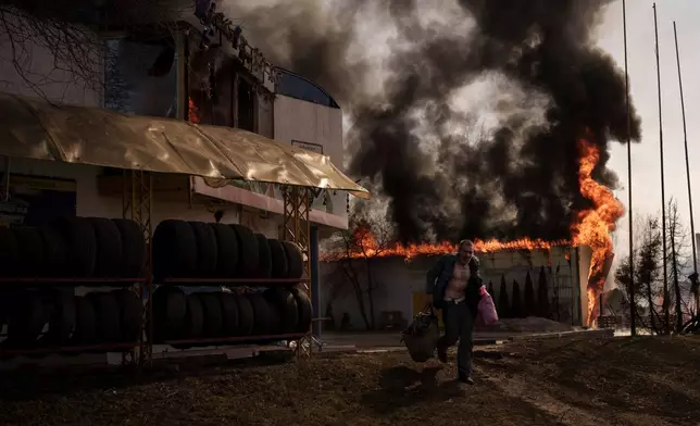 FILE - A man recovers items from a shop that caught fire in a Russian attack in Kharkiv, Ukraine, Friday, March 25, 2022. (AP Photo/Felipe Dana, File)