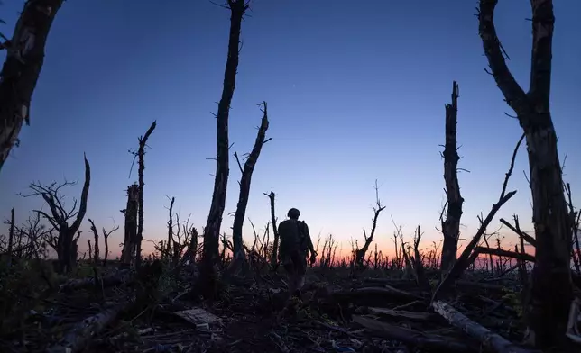 FILE - Ukrainian servicemen walk through a charred forest along the front line, a few kilometers from Andriivka, Donetsk region, Ukraine, Saturday, Sept. 16, 2023. (AP Photo/Mstyslav Chernov, File)
