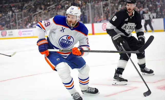 Edmonton Oilers center Leon Draisaitl, left, skates against Los Angeles Kings defenseman Joel Edmundson during the first period of an NHL hockey game Thursday, Feb. 26, 2026 in Los Angeles. (AP Photo/Ryan Sun)