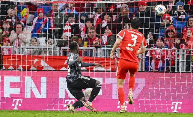 Frankfurt's Arnaud Kalimuendo, left, scores during the Bundesliga soccer match between Bayern Munich and Eintracht Frankfurt in Munich, Germany, Saturday Feb. 21, 2026. (Harry Langer/dpa via AP)