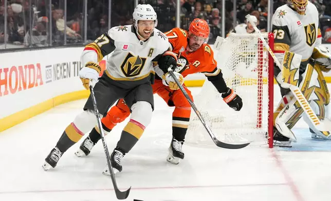 Vegas Golden Knights defenseman Shea Theodore, left, moves the puck while under pressure from Anaheim Ducks left wing Alex Killorn during the first period of an NHL hockey game Sunday, Feb. 1, 2026, in Anaheim, Calif. (AP Photo/Mark J. Terrill)