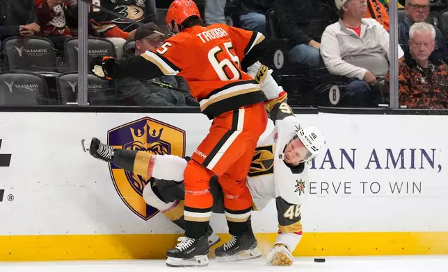Vegas Golden Knights right wing Jonas Rondbjerg, right, falls after being hit by Anaheim Ducks defenseman Jacob Trouba during the second period of an NHL hockey game Sunday, Feb. 1, 2026, in Anaheim, Calif. (AP Photo/Mark J. Terrill)