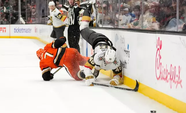 Anaheim Ducks defenseman Radko Gudas, left, falls after hip checking Vegas Golden Knights right wing Jonas Rondbjerg during the second period of an NHL hockey game Sunday, Feb. 1, 2026, in Anaheim, Calif. (AP Photo/Mark J. Terrill)