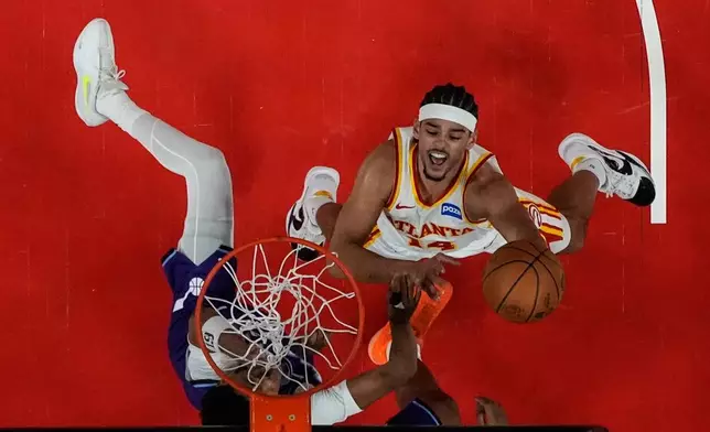 Atlanta Hawks forward Asa Newell (14) shoots against against the Utah Jazz during the first half of an NBA basketball game, Thursday, Feb. 5, 2026, in Atlanta. (AP Photo/Mike Stewart)