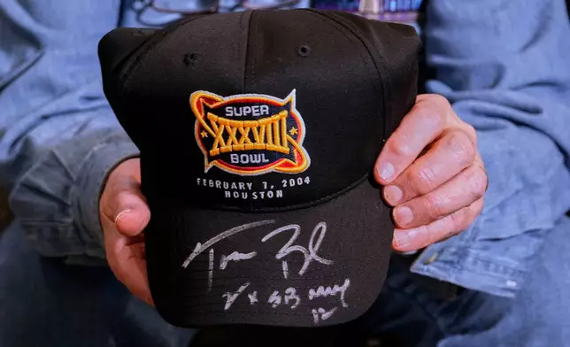 Don Crisman holds a Super Bowl 38 souvenir hat signed by Hall of Fame quarterback Tom Brady, Friday, Jan. 23, 2026, in Kennebunk, Maine. (AP Photo/Robert F. Bukaty)