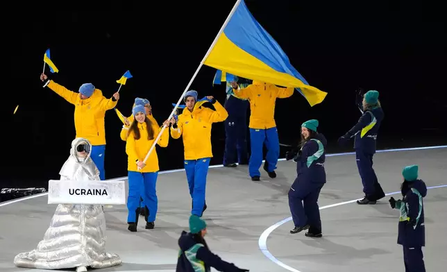 Yelyzaveta Sydorko, flag bearer of Ukraine, leads Ukrainian athletes during the Olympic opening ceremony at the 2026 Winter Olympics, in Milan, Italy, Friday, Feb. 6, 2026. (AP Photo/Lee Jin-man)