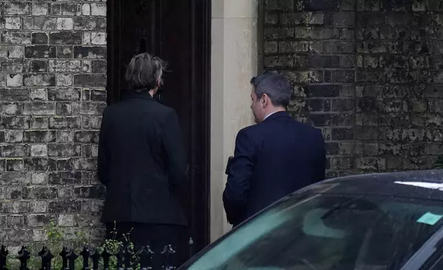 Two people wait to enter the home of Lord Peter Mandelson in north west London, Friday, Feb. 6, 2026. (Maja Smiejkowska/PA via AP)