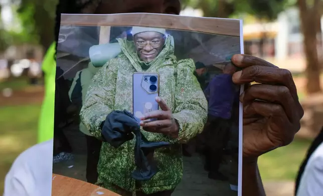 A family member of Kenyan who joined the Russian army in Ukraine hold photos of their loved ones during a protest urging the government to repatriate them and their remains in Nairobi, Thursday, Feb. 19, 2026. (AP Photo/Andrew Kasuku)