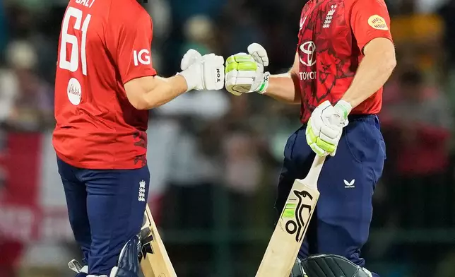 England's Jos Buttler, left, celebrates with England's Phil Salt after hits a boundary during the second T20 cricket match between England and Sri Lanka in Pallekele, Sri Lanka, Sunday, Feb, 1. 2026. (AP Photo/Eranga Jayawardena)