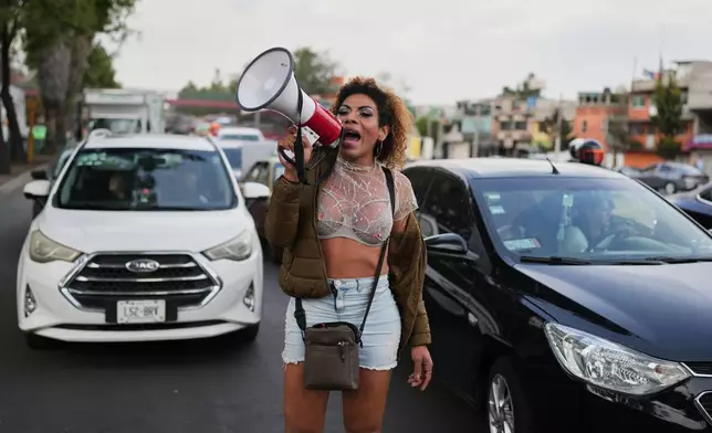 Carolina, a sex worker, protests outside a city office responsible for the construction of a bike lane ahead of the World Cup soccer tournament, which blocks cars from pulling over along Calzada de Tlalpan and closes the metro at night, in Mexico City, Friday, Jan. 23, 2026. (AP Photo/Eduardo Verdugo)