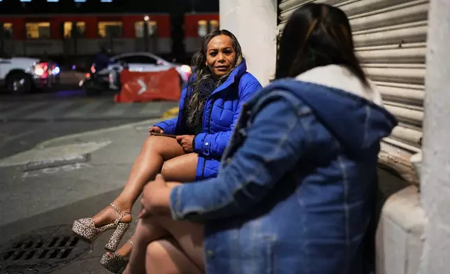 Montserrat Fuentes, left, speaks with a fellow sex worker on Calzada de Tlalpan where she has worked for 20 years and the city is building a bike lane that blocks cars from pulling over and closes the metro at night, in Mexico City, Friday, Jan. 30, 2026. (AP Photo/Eduardo Verdugo)