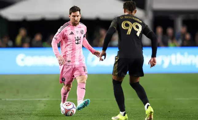 Inter Miami forward Lionel Messi, left, passes the ball Los Angeles FC forward Denis Bouanga (99) during the first half of an MLS soccer match, Saturday, Feb. 21, 2026, in Los Angeles, Calif. (AP Photo/Jessie Alcheh)