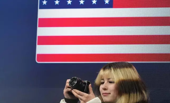 Alysa Liu of the United States takes photos before the figure skating men's team event at the 2026 Winter Olympics, in Milan, Italy, Saturday, Feb. 7, 2026. (AP Photo/Francisco Seco)