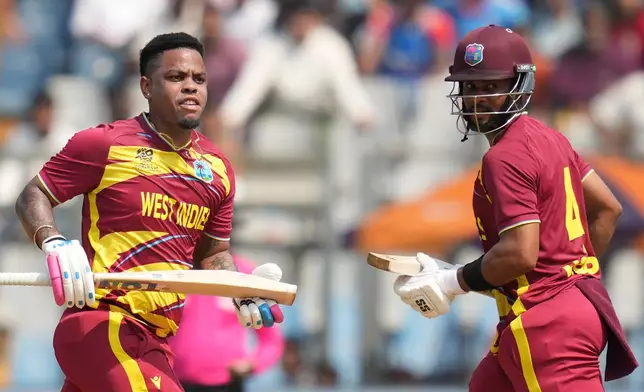 West Indies' captain Shai Hope, right and Shimron Hetmyer run between the wickets to score during the T20 World Cup cricket match between Nepal and West Indies in Mumbai, India, Sunday, Feb. 15, 2026. (AP Photo/Rafiq Maqbool)