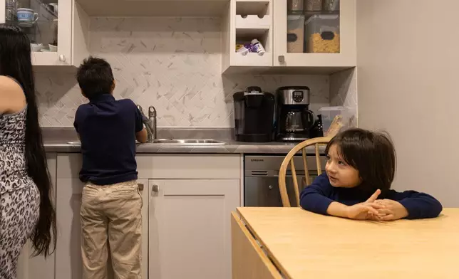 Yair, 3, right, waits for his mom to prepare breakfast while his brother Giancarlo, 10, washes his hands Tuesday, Feb. 3, 2026, in Minneapolis. (AP Photo/Liam James Doyle)