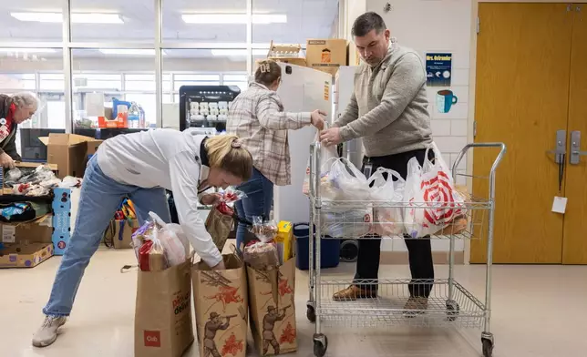 Valley View Elementary School principal Jason Kuhlman, right, helps organize and pack food donations for delivery Tuesday, Feb. 3, 2026, in Columbia Heights, Minn. (AP Photo/Liam James Doyle)
